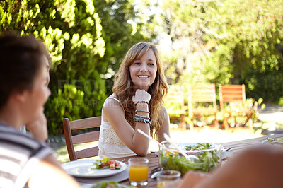 Buy stock photo Smiling young woman at a lunch with a group of friends