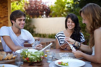 Buy stock photo Friends, card game and food in backyard for lunch and discussion with a smile and fun. Salad, laughing and young people outdoor of a home with communication and funny joke together with a meal