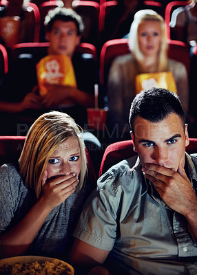 Buy stock photo Cinema, shock and couple with popcorn, watching film or eating on romantic date together. Movie night, man and woman in theater with snacks, horror and sitting in auditorium to relax at show premier.