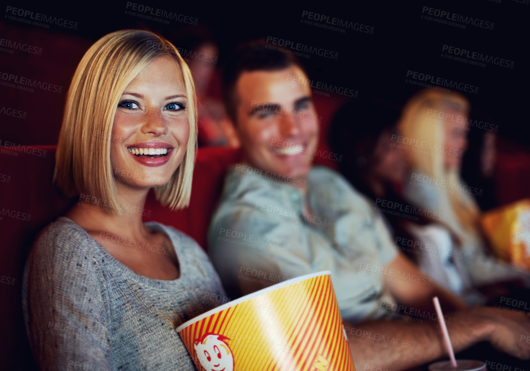 Buy stock photo Movie, popcorn and smile with woman on a date with man at cinema interior or theater event. Happy, film or show screen with couple eating snacks and watching together at night time