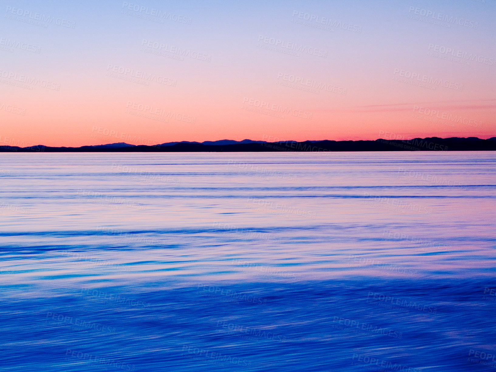 Buy stock photo A calm lake and a gorgeous sunset with a serene view at the sunset. Relaxing seascape with a vast horizon of the sky and the sea with copyspace. Skyscape of dawn with gradient sky at a seaside