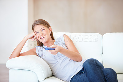 Buy stock photo Young woman watching tv and laughing while changing the channel