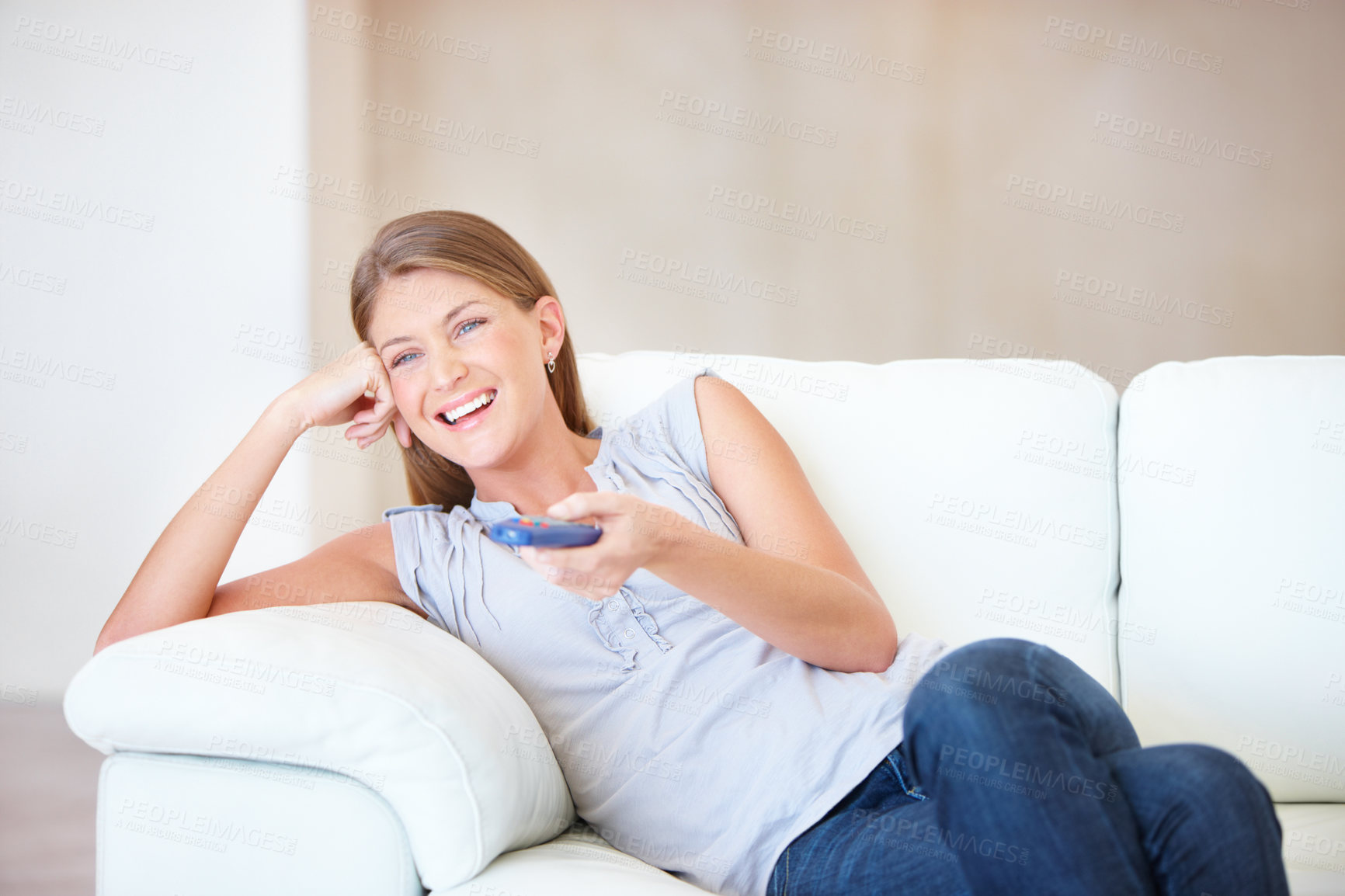 Buy stock photo Young woman watching tv and laughing while changing the channel