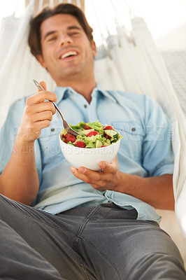 Buy stock photo Happy, man and eating a healthy salad in a hammock for travel, freedom and wellness, diet or detox on vacation. Food, brunch and cheerful male vegetarian with vegetable meal outdoor for nutrition