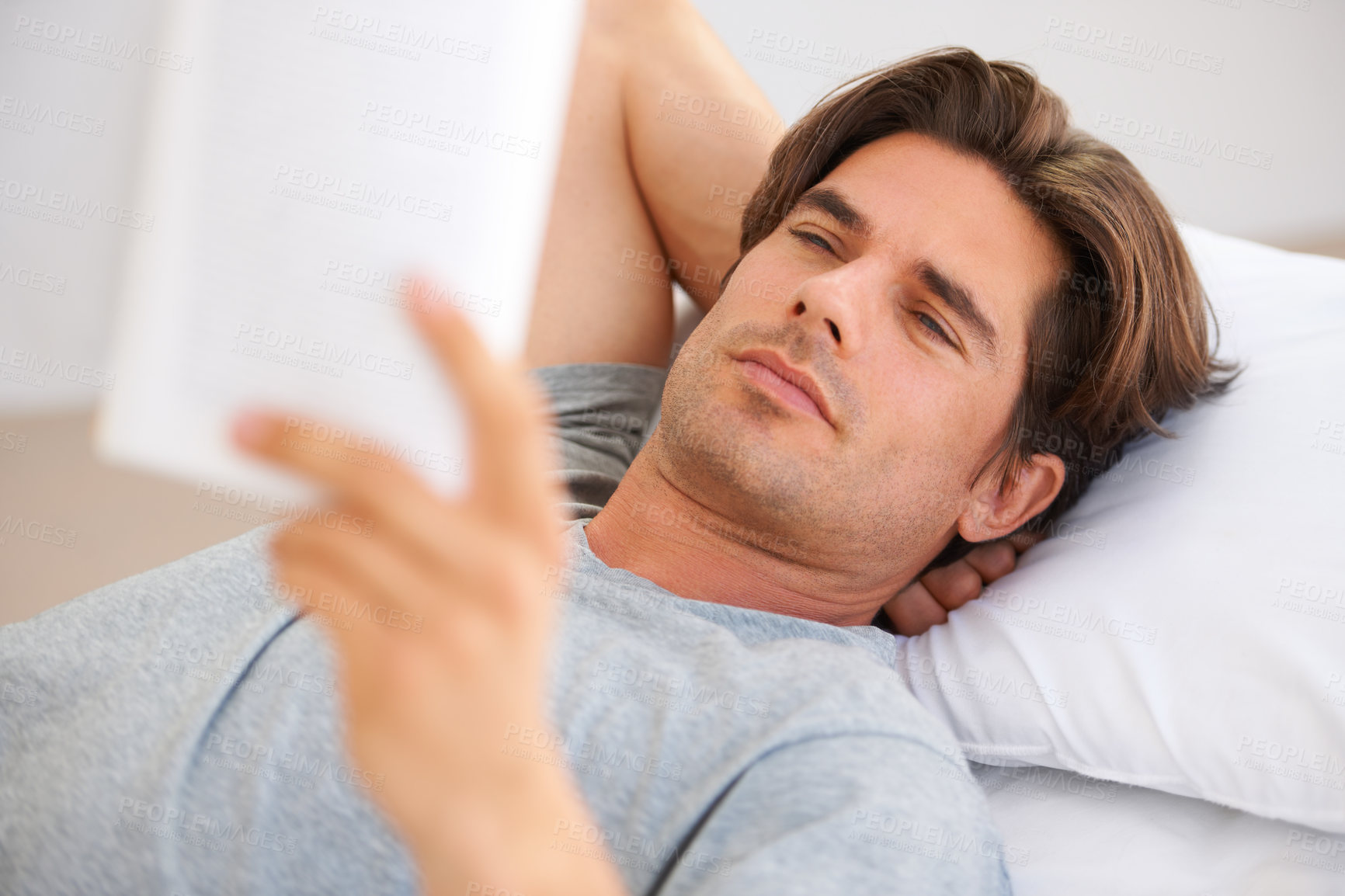 Buy stock photo Man, bedroom and reading story in book, interesting novel and learning knowledge at home. Serious guy relax with notebook of fiction for break, studying literature or hobby to enjoy in comfort on bed