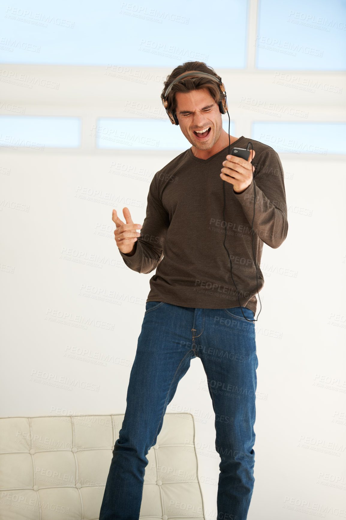 Buy stock photo Dance, headphones or happy man singing with phone to celebrate freedom, karaoke subscription or hearing digital audio. Excited guy listening to music, radio or sound on smartphone with energy at home