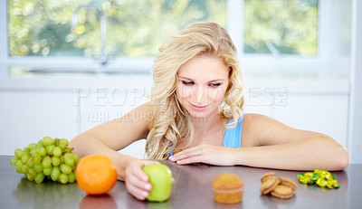Buy stock photo Pretty young woman being tempted to eat unhealthy food