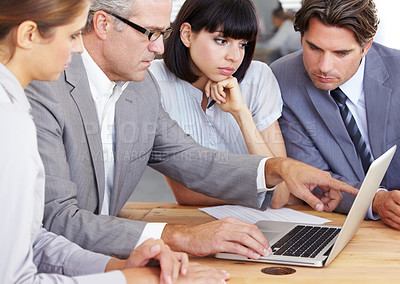 Buy stock photo A team of businesspeople working on a laptop together