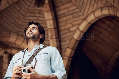 Buy stock photo Thinking, photographer or tourist in building on holiday, vacation or weekend trip for an adventure in Italy. Man, city travel or low angle of person with camera sightseeing in urban town on journey