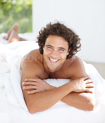 Buy stock photo Portrait, happy and weekend with a man on a bed in his home to relax or rest on a summer morning. Smile, wellness and bedroom with an attractive young male person relaxing alone in his house