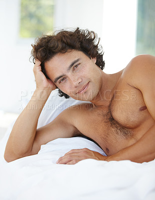 Buy stock photo Portrait of a handsome young man lying in bed at home