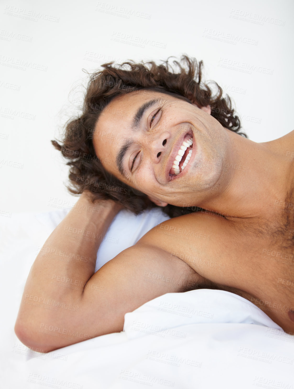 Buy stock photo Face, laugh and a handsome man in bed in his home to relax or rest alone on a summer morning. Smile, wellness and lifestyle with a happy young male person relaxing in the bedroom of his house