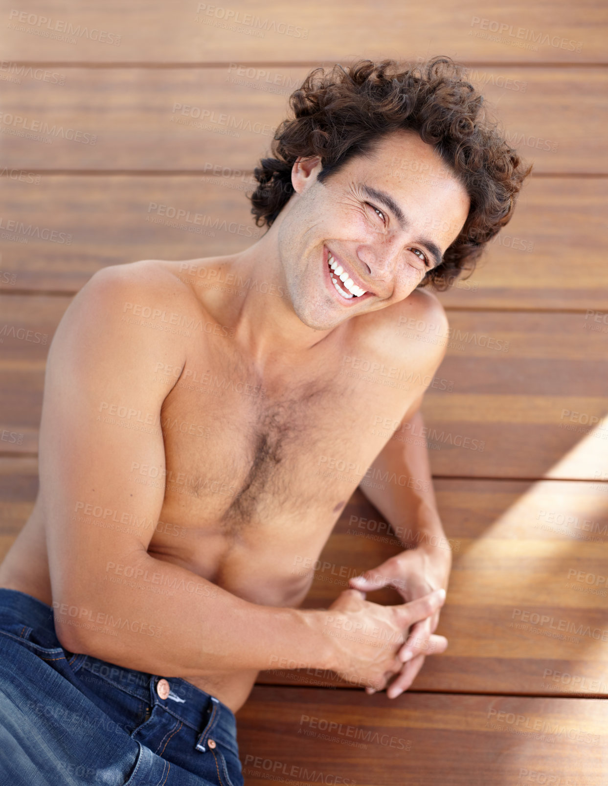 Buy stock photo Shirtless man, portrait and happpy guy in jeans laying down on wood floor with happy and sexy smile. Attractive, healthy and topless male laughing with relaxing, rest and bare chest in sunshine
