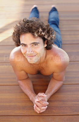 Buy stock photo Portrait, topless and a man lying on a wooden deck outdoor in summer to relax or rest during the day. Sexy, shirtless and hot with a handsome young male person resting on a wood floor from above