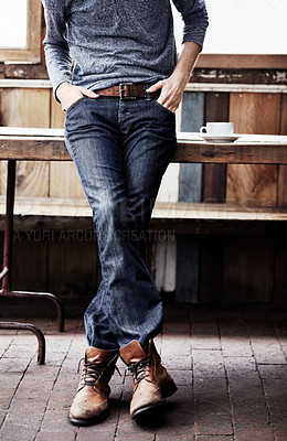 Buy stock photo Fashion, casual and closeup of a man at a coffee shop with a trendy, cool and stylish outfit. Shirt, denim jeans and zoom of a male person with edgy style standing at a wood table in a cafeteria.