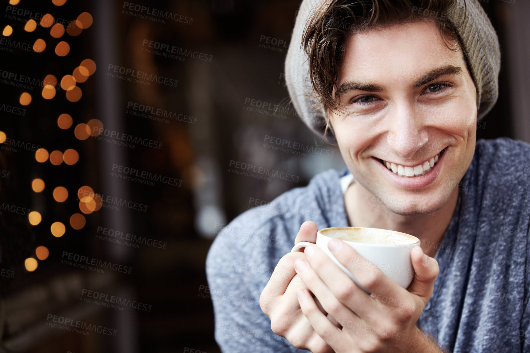 Buy stock photo A young male smiling as he holds his coffee