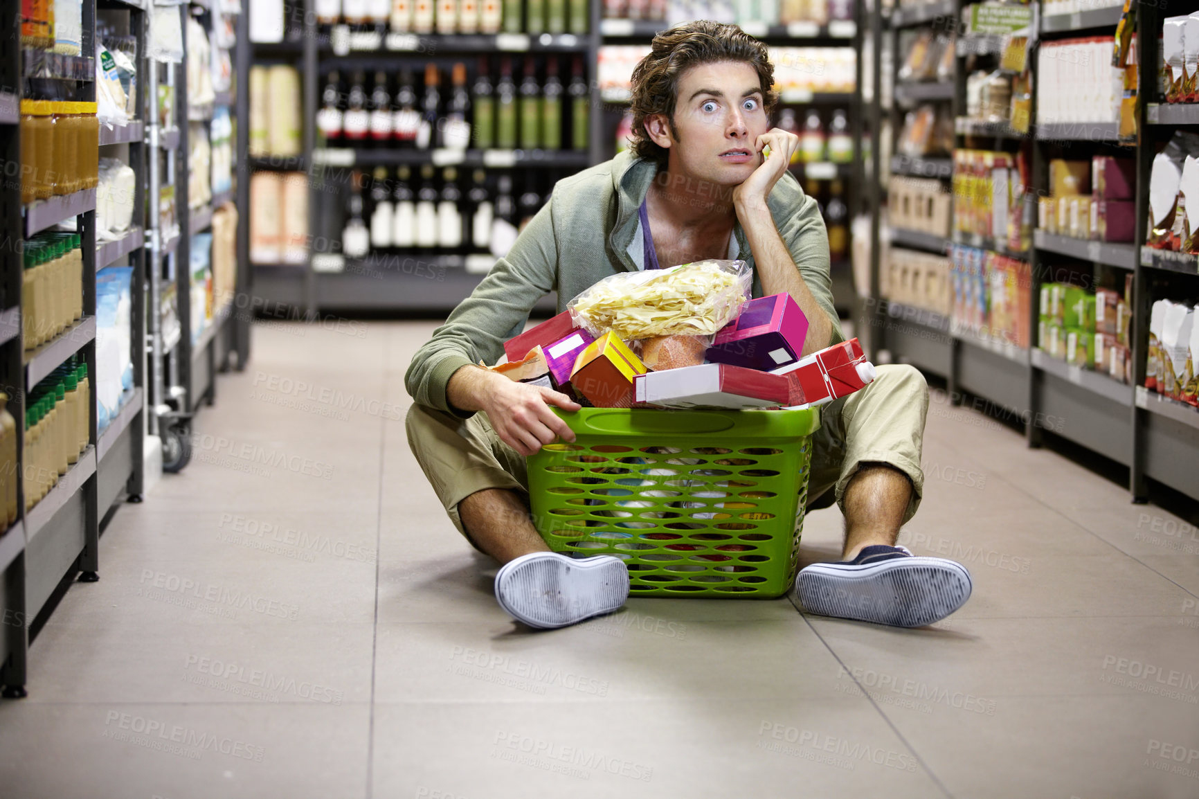 Buy stock photo Man, grocery shopping and supermarket, stress about inflation and expensive food, overwhelmed in store. Groceries in basket, retail and customer shocked by price, choice and purchase with fear