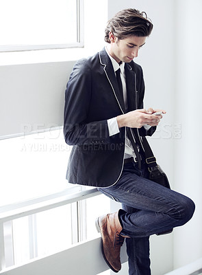 Buy stock photo Fashion, phone and young man networking on social media, mobile app or the internet with formal outfit. Business, technology and male person scroll on a cellphone with classy, cool and elegant style.