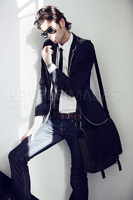 Buy stock photo Fashion, formal and handsome man by a wall with stylish, cool and trendy outfit and briefcase. Sunglasses, bag and young male model from Canada with elegant and classy style by white background.