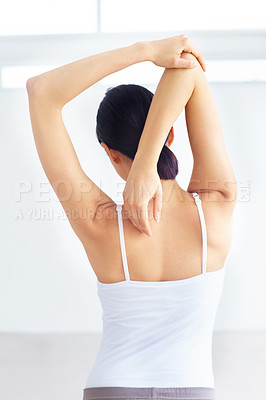 Buy stock photo Young woman stretching while indoors - rear view
