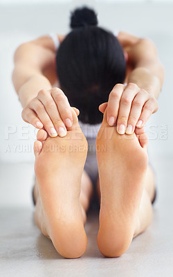 Buy stock photo Young woman touching her toes in a stretch