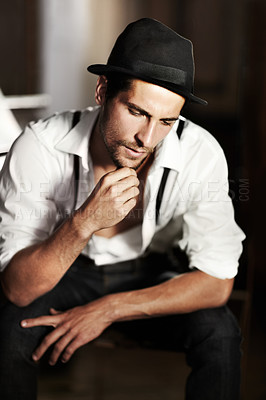 Buy stock photo Man, hipster and thinking about fashion, ideas or choice of clothes in dark background. Clothing, decision and creative person or model sitting and planning outfit with vintage hat and retro style