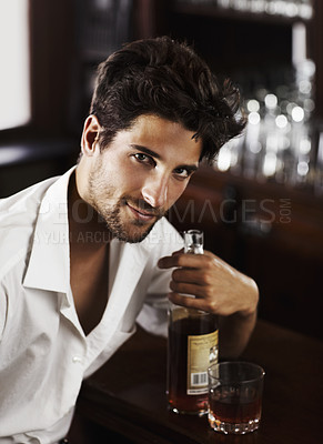 Buy stock photo Man, pub counter and portrait with drink at happy hour with alcohol and whiskey after work. Bottle, male person and face of a handsome guy with a glass and style and confidence in a luxury bar