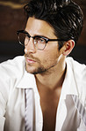 Sexy young man looking away while wearing glasses and a slightly parted shirt