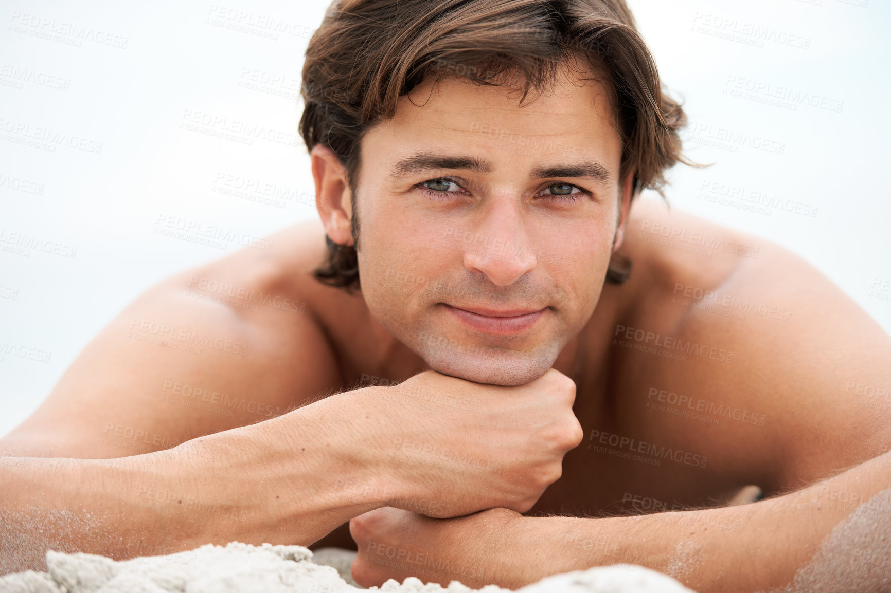 Buy stock photo Shot of a handsome young man enjoying a relaxing day at the beach