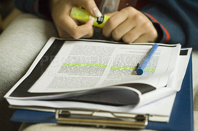Buy stock photo Shot of a student highlighting text while studying
