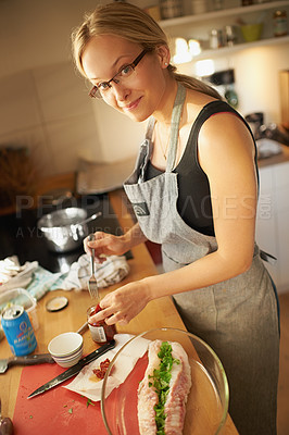 Buy stock photo Attractive young woman preparing a meal in her kitchen