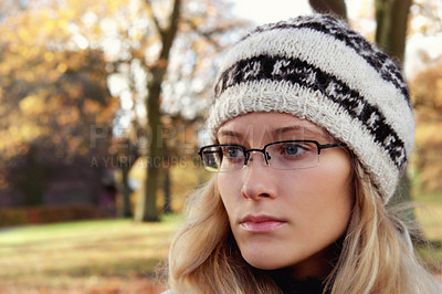 Buy stock photo Face, thinking and glasses with a woman in the park during an autumn or winter morning to relax. Idea, fashion or beanie and a young person in a garden outdoor to view nature with blurred space