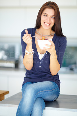 Buy stock photo Portrait of a smiling young woman eating a healthy fruit salad for lunch