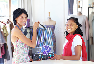Buy stock photo An attractive young ethnic woman handing over a package to a customer