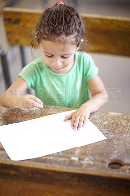 Buy stock photo Sweet little girl sitting at a school desk and drawing