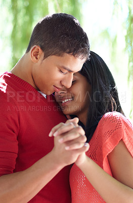 Buy stock photo Shot of an affectionate young couple holding hands outdoors
