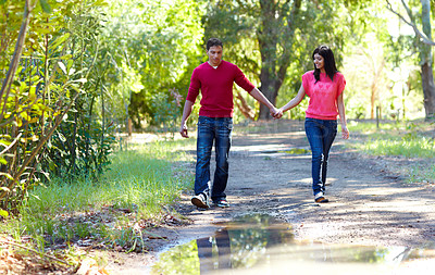 Buy stock photo Shot of an affectionate young couple going for a walk outdoors