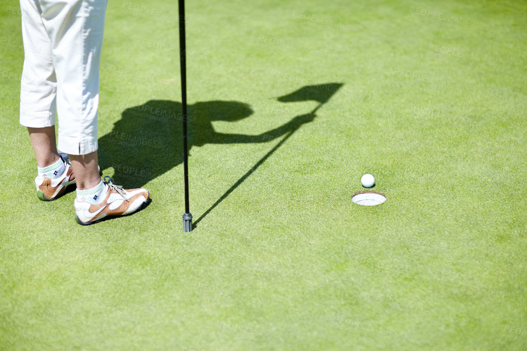Buy stock photo Flag, shoes or person playing golf for fitness, workout or exercise with ball shadow on a green course. Legs of golfer, golfing or feet of athlete training or exercising in a sports game or practice 