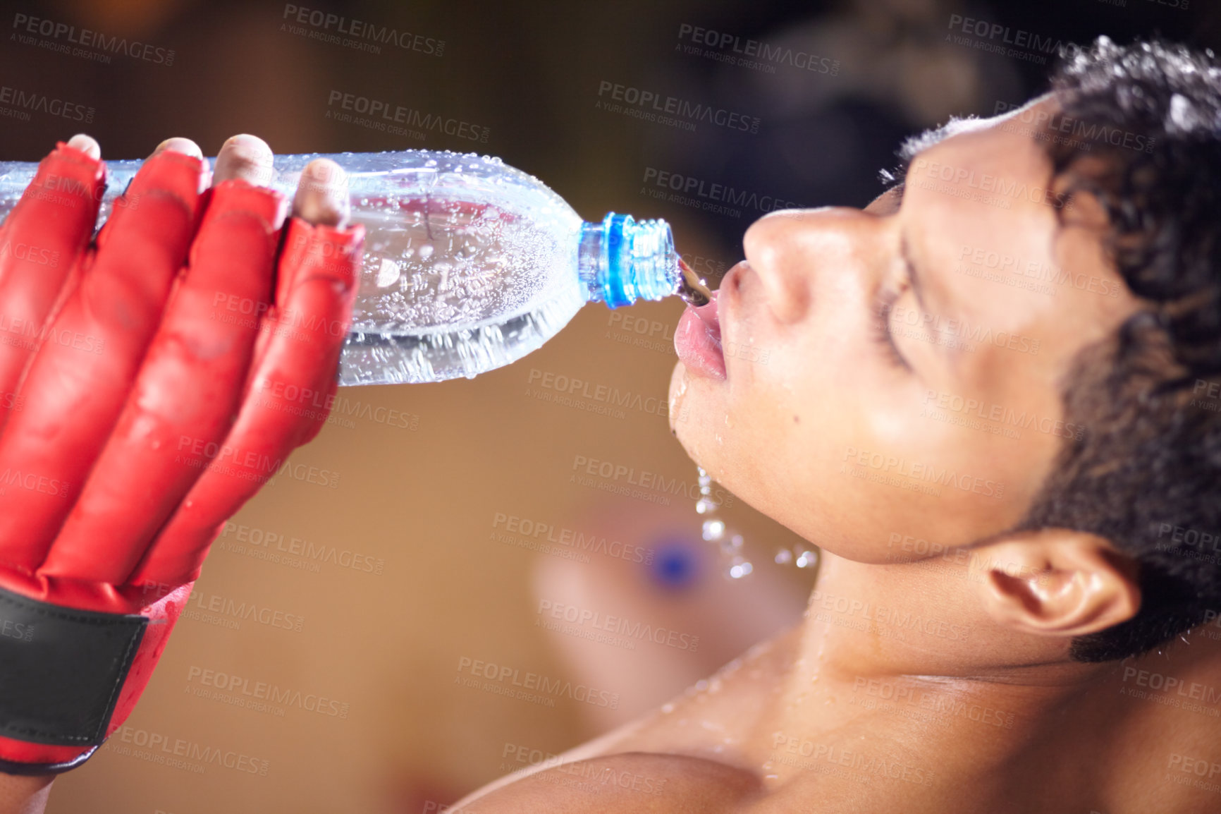 Buy stock photo A high angle view of a young fighter drinking from a bottle of water