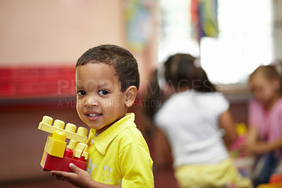 Buy stock photo Boy, learning and building blocks in classroom for development, scholarship and thinking at kindergarten. Happy student child, plastic toys and smile for education at academy, school or idea in class