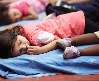 Buy stock photo Kindergarten, children and group sleeping, relax and resting after education. Nursery, sleep and tired students take nap to rest together after learning, studying and knowledge in preschool classroom