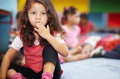 Buy stock photo Girl child, biting nails and classroom for anxiety, thinking or nervous in kindergarten for education. Kid, preschool and hand in mouth with stress for learning, development or scholarship at academy