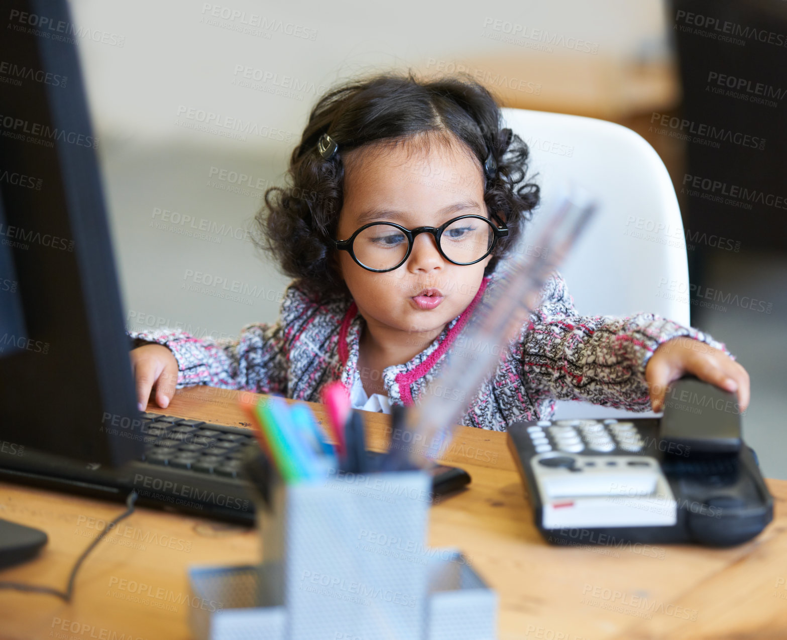 Buy stock photo Shot of an adorable little girl playing businesswoman at a desk