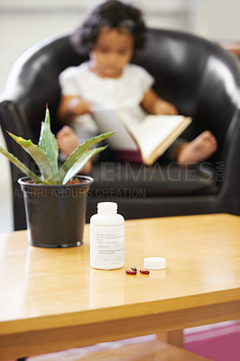 Buy stock photo Pills, bottle and young child reading for adhd diagnosis, school work learning or education. Medication, capsules or daughter or book concentration in home development discipline, childhood or growth