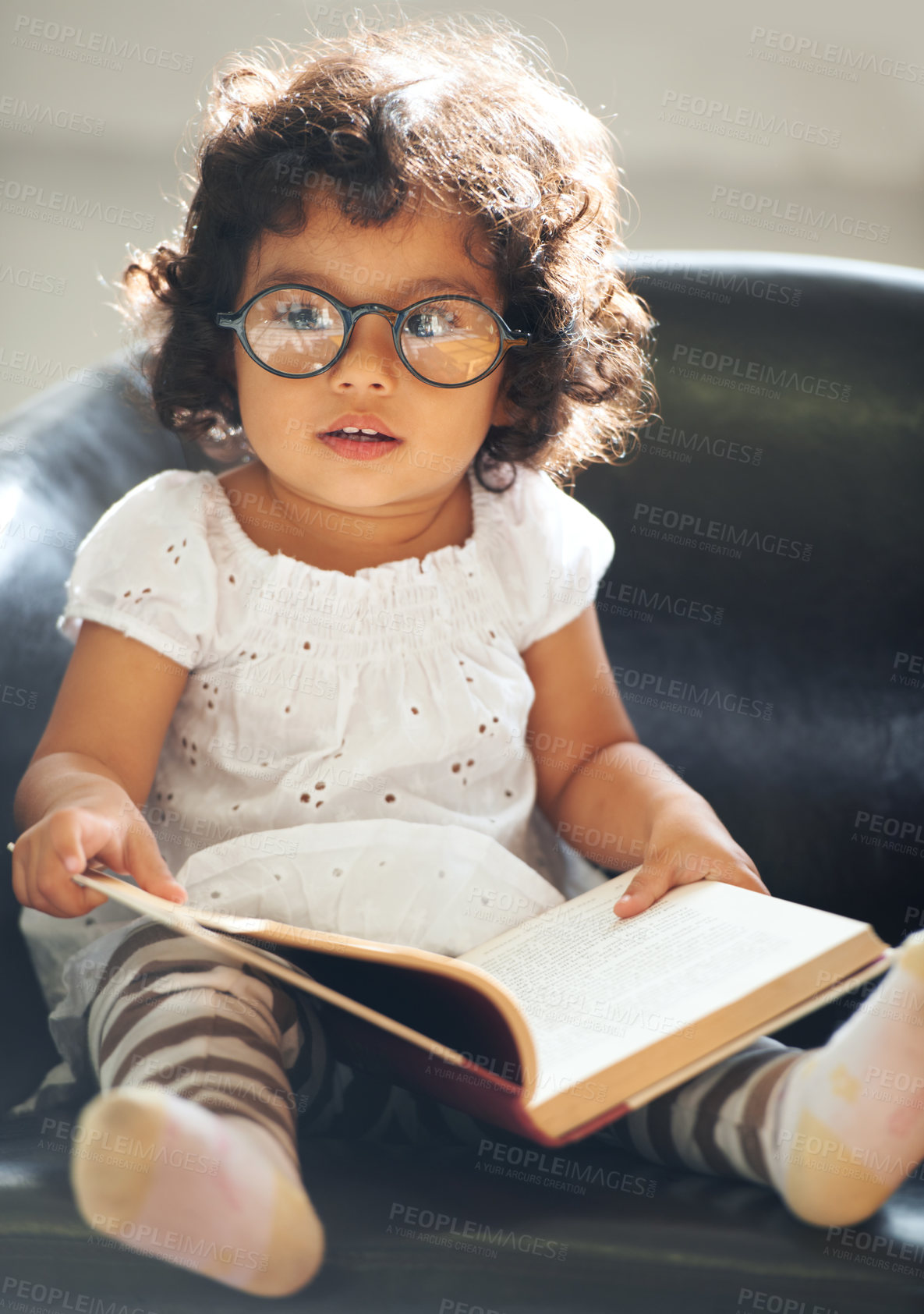 Buy stock photo Relax, sofa and a child reading a book for education, learning and knowledge in a house. Morning, smart and a girl, kid or baby with a story and glasses for studying or childhood on the couch
