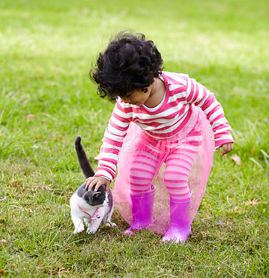 Buy stock photo Adorable little girl on the lawn outside stroking a cute kitten