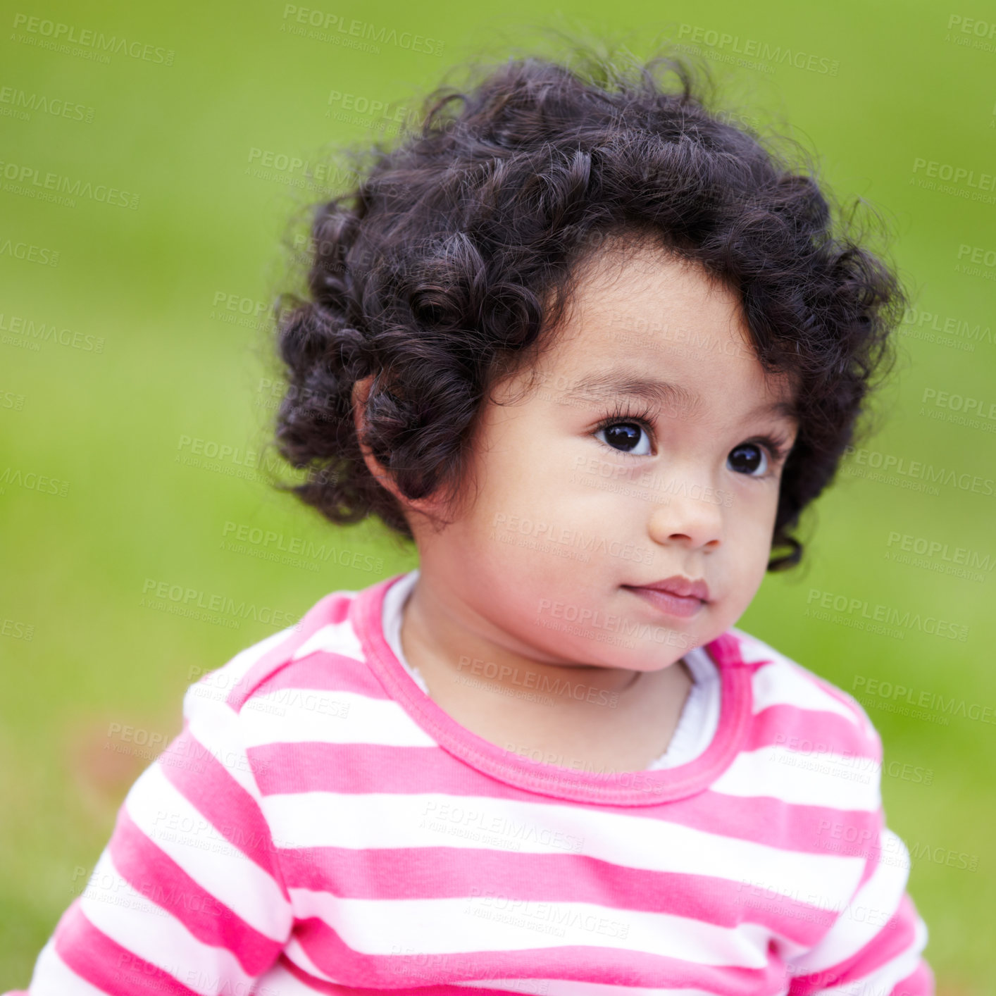 Buy stock photo Girl, toddler and face for outside, grass or park for child development. Adorable kid, curly hair and alone in pink clothes with expression for curiosity on field in garden with backyard for playing