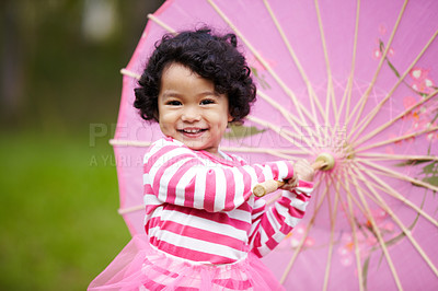 Buy stock photo Adorable little girl playing with a paper umbrella while outside