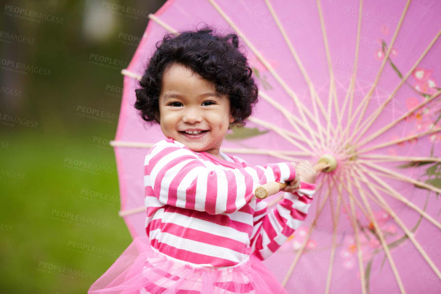 Buy stock photo Adorable little girl playing with a paper umbrella while outside