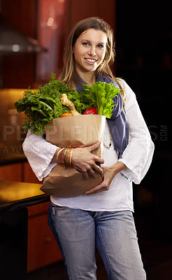 Buy stock photo Attractive woman holding a paper bag of fresh vegetables